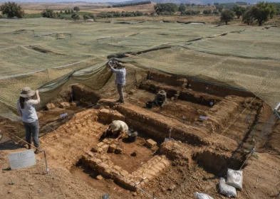 Field archaeological dig site covered by protective camouflage netting