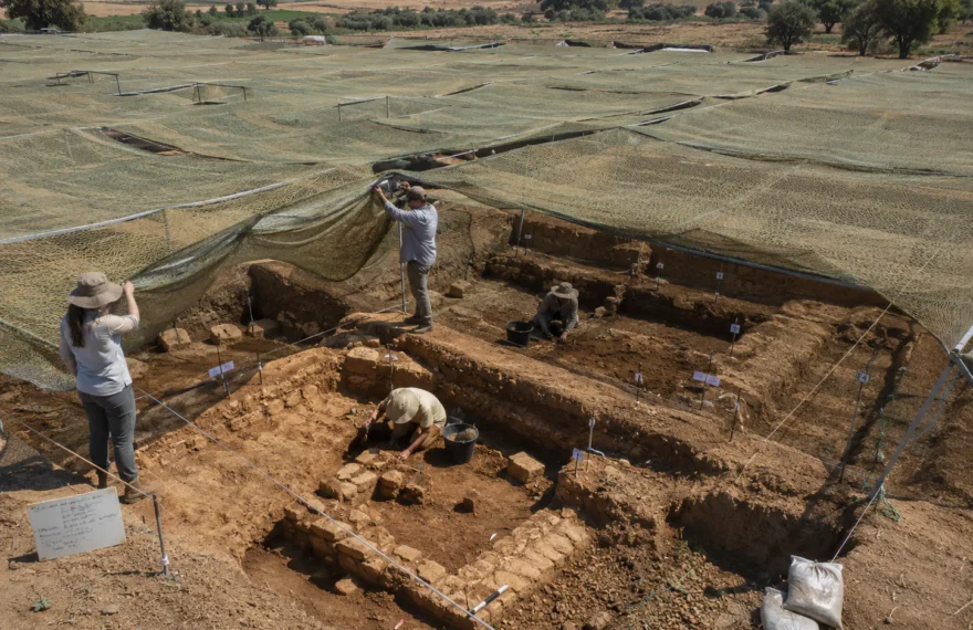 Field archaeological dig site covered by protective camouflage netting