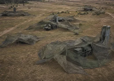 Field archaeological dig site covered by protective camouflage netting