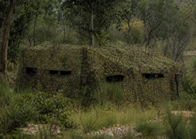 Wildlife observation blind hidden with silent forest camouflage netting