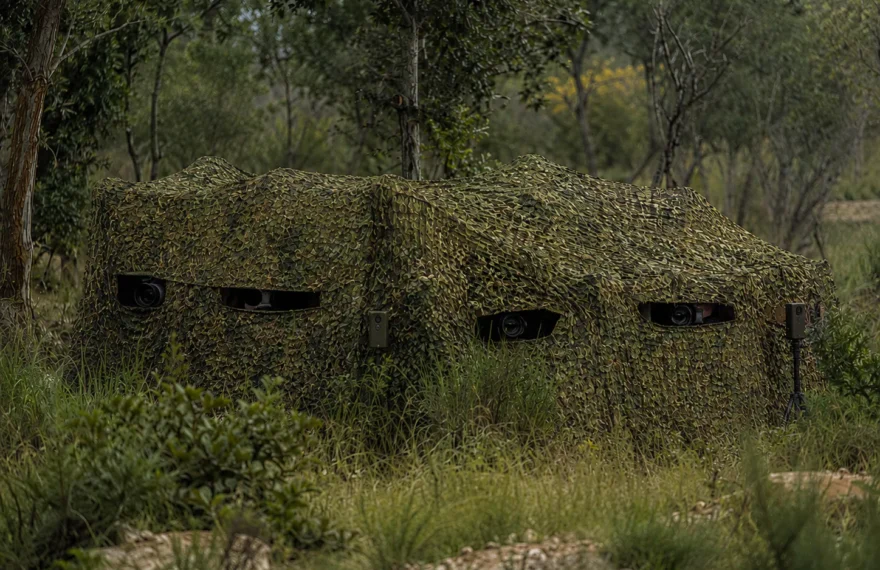 Wildlife observation blind hidden with silent forest camouflage netting